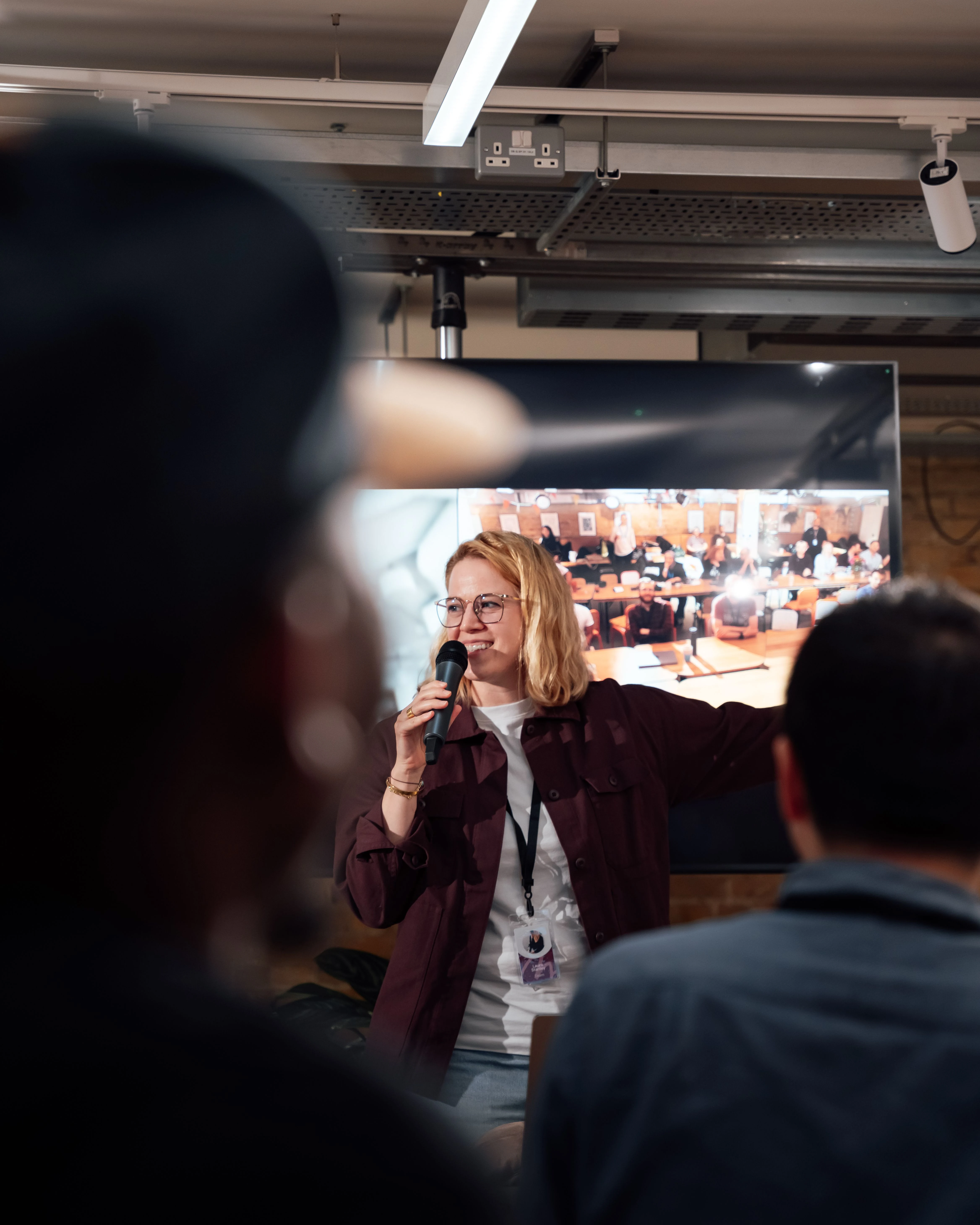 A woman speaking with an audience at a community event in London